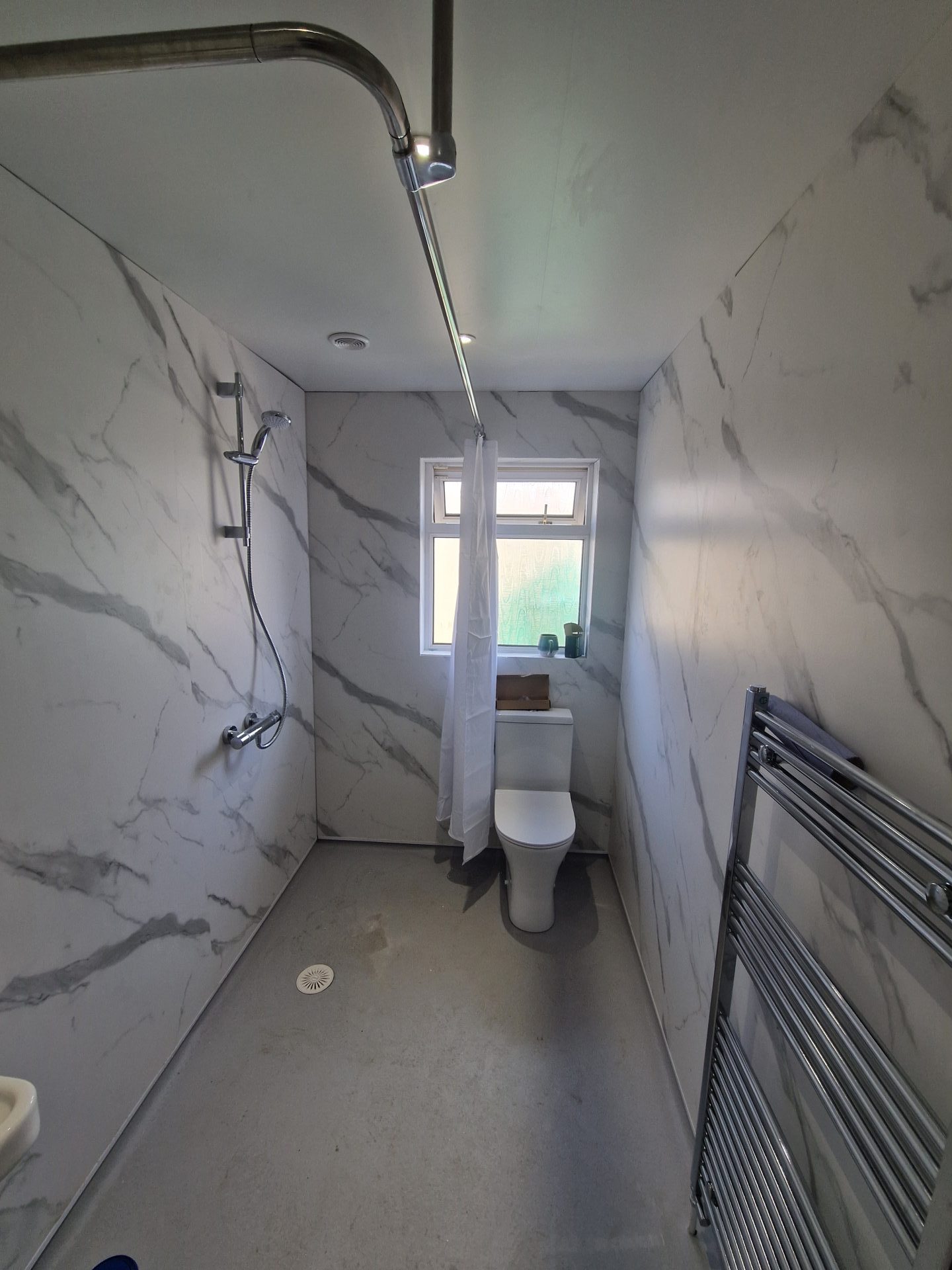 Bathroom with a shower, toilet, and marble walls