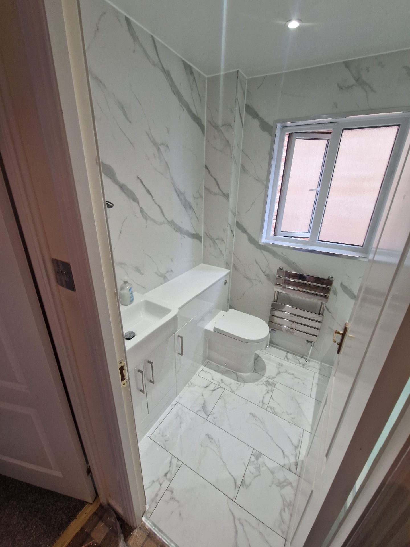 Small bathroom with marble walls and modern fixtures